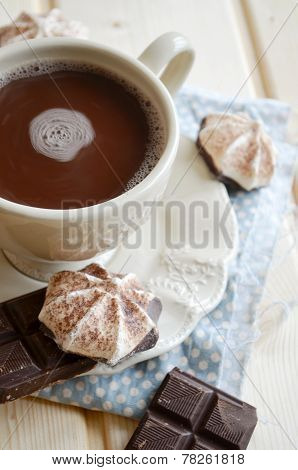 Hot cocoa with marshmallows and chocolate on wooden table
