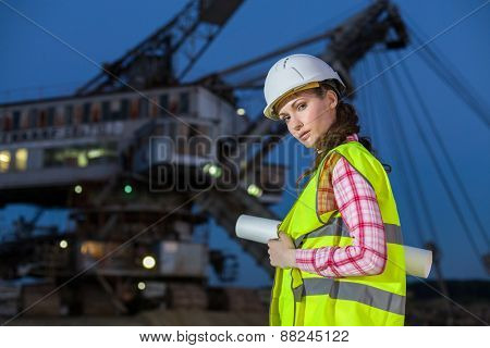 female worker holding scheme on rails on backgroud of career stacker