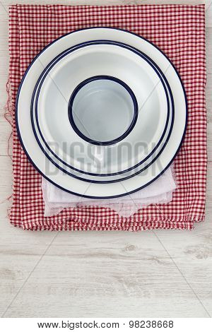 Vintage Enamelware Crockery On Retro Cloths On Rustic Wooden Background