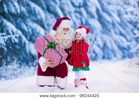 Santa Claus Talking To Little Girl In Snowy Park