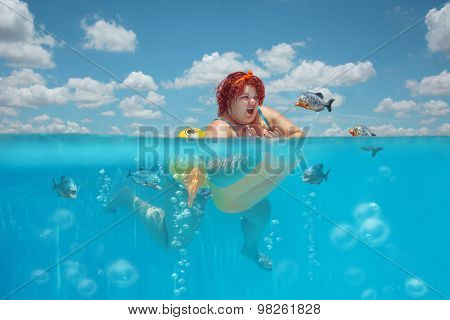 Beautiful young fat woman is swimming with yellow duck lifebuoy and defending oneself against flock of piranhas 