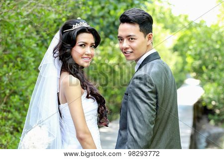 Newlywed Couple Holding Hands And Looking Back
