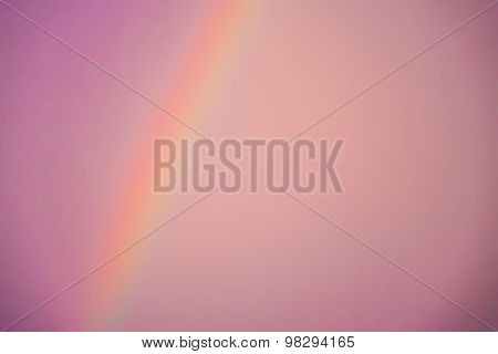 Blurred abstract pinkish background of a rainbow and the sky