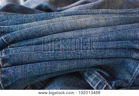 A few jeans close-up. Old worn jeans are not neatly folded.