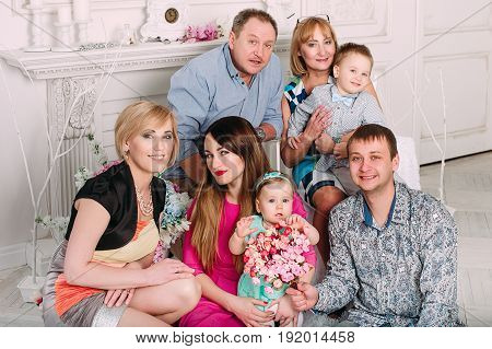 Three Generation Family Sitting On Sofa Together. Classic Portrait