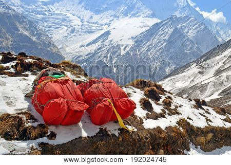 Two huge red backpacks for mountain expedition on snow. Porter Mountaineering equipment. Nepal, Annapurna Base Camp track.