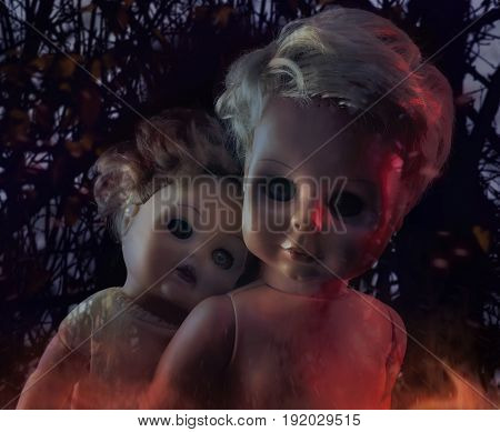 Horror dolls photo. Two burning creepy ghost dolls on mystic nature background photo.