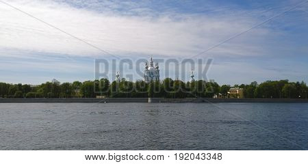 View of the Smolny Cathedral in St. Petersburg from the Sverdlovskaya embankment. The Neva river in the foreground