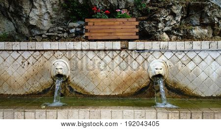 The famous fountain with the flowing water from the lions ' mouths in the village of Spili in Crete