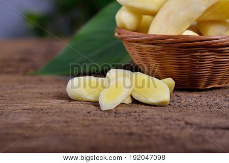 cut fresh young turmeric on wooden table and in bamboo basket