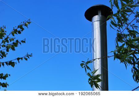 Iron pipe from the stove against the sky