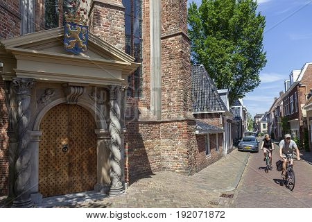 Leeuwarden Netherlands 11 june 2017: couple on bicycle pass the orange porch of the large or Jacobin church in leeuwarden
