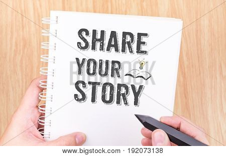 Share Your Story Word On White Ring Binder Notebook With Hand Holding Pencil On Wood Table,business
