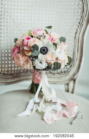 Wedding accessories: boutonniere and bride's bouquet on the chair