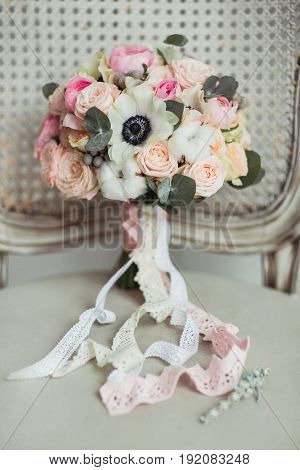 Wedding accessories: boutonniere and bride's bouquet on the chair