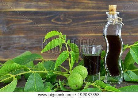 Close up of walnut liqueur on wooden background