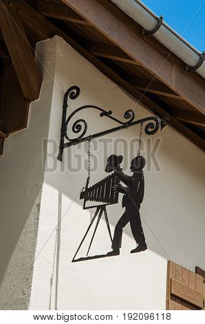 Megève, France - June 25, 2016. View of street with shop, cinema and madam with dog in Megève, a famous ski resort located in Haute-Savoie Province, near the Mont Blanc in the French Alps