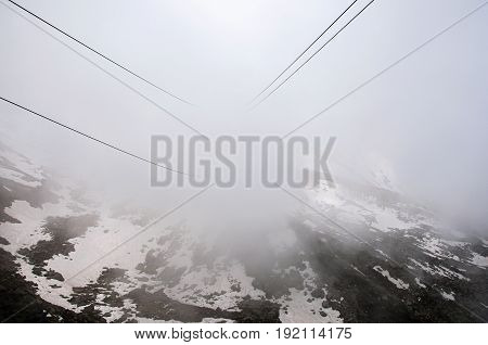 View of cable car cables on the way up to the Aiguille du Midi, in French Alps Chamonix Mont Blanc, alpine mountains landscape, cloudy weather.