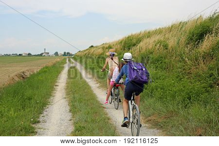 Family with Three people with two bicycles along the cycle path in the nature reserve