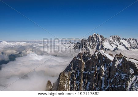 View of snowy peaks from the Aiguille du Midi, in French Alps Chamonix Mont Blanc, alpine mountains landscape, clear blue sky in warm sunny summer day