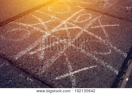 Strategic game of tic tac toe played on street pavement selective focus