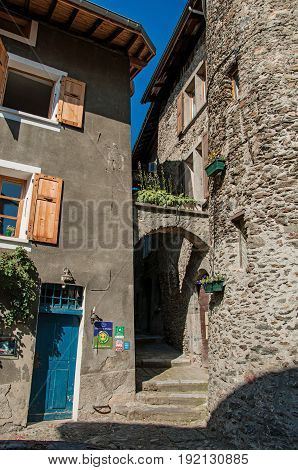 Conflans, France - June 29, 2016. Alley with arch and buildings, in the city center of the medieval hamlet of Conflans, department of Haute-Savoie, Auvergne-Rhône-Alpes region, south-eastern France