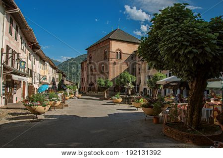 Conflans, France - June 29, 2016. Square with stone building and shops in the city center of Conflans, a medieval hamlet in Haute-Savoie department, Auvergne-Rhône-Alpes region, south-eastern France