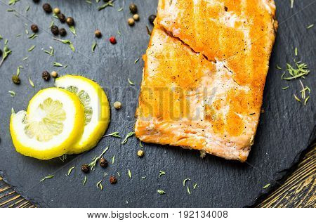 Grilled salmon steak with fresh lemon top view.