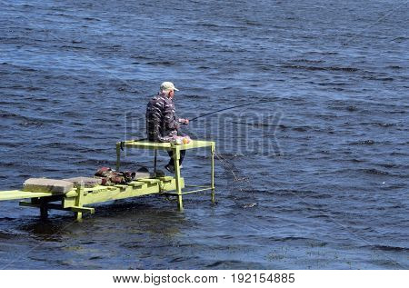 An unidentified person fishing.Modern residential area Obolon.June 21 ,2017 in Kiev, Ukraine