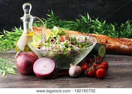Bowl Of Salad With Vegetables And Greens On Wooden Table