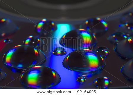 Compact Disc CD with water drops on the data surface with a shiny colorful reflection