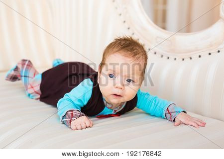 adorable baby boy lying on tummy in the bedroom