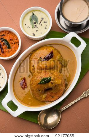 south indian food called vada sambar or sambar vada or wada dipped in sambar with coconut, green and red chutney and south indian style hot coffee, selective focus