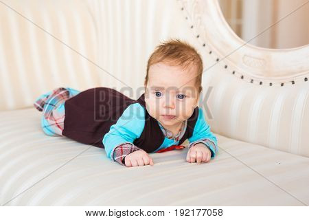 adorable baby boy lying on tummy in the bedroom