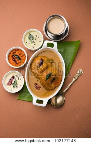 south indian food called vada sambar or sambar vada or wada dipped in sambar with coconut, green and red chutney and south indian style hot coffee, selective focus