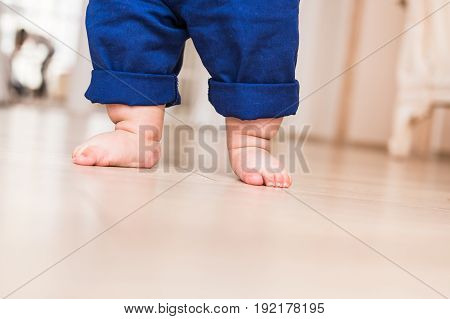 Portrait of mother and baby legs. First steps.