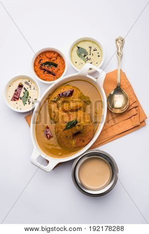 south indian food called vada sambar or sambar vada or wada, served with coconut, green and red chutney over fresg banana leaf, selective focus