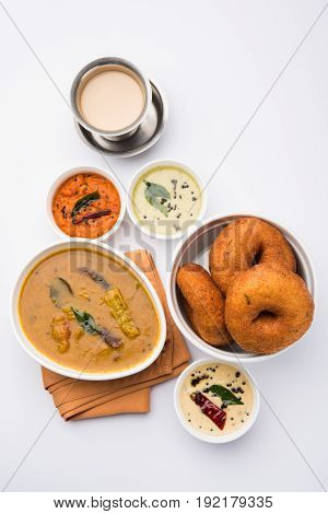 south indian food called vada sambar or sambar vada or wada, served with coconut, green and red chutney over fresg banana leaf, selective focus