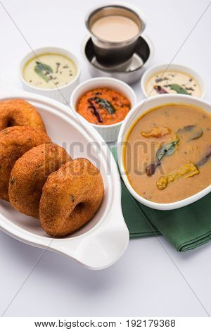 south indian food called vada sambar or sambar vada or wada, served with coconut, green and red chutney over fresg banana leaf, selective focus