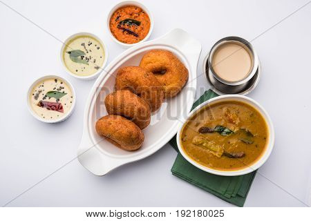 south indian food called vada sambar or sambar vada or wada, served with coconut, green and red chutney over fresg banana leaf, selective focus