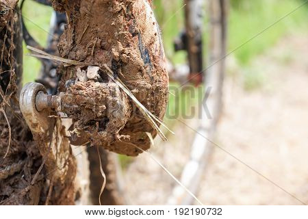 Mountain bike clipless shoes with mud and dirt stuck in the pedal / Cycling in wet and muddy condition concept