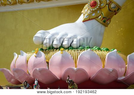 close up foot big white statue of brahma on lotus in public temple at Thailand