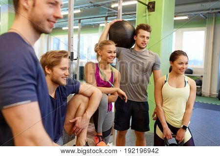 fitness, sport, exercising and healthy lifestyle concept - group of happy people with skipping rope, medicine ball and kettlebell in gym