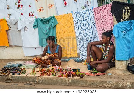Hell-Ville Madagascar - December 19 2015: Indigenous women sell colorful embroidered tablecloths fabrics and souvenirs on the road at the Hell-Ville (Andoany) Nosy Be Island Madagascar.