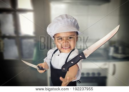 Funny portrait of a four years girl dressed as a cook throwing a knife