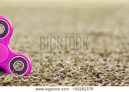 Closeup of the popular pink spinner gadget in 2017 of the soccer (football) artificial field