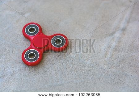 Red Fidget Spinner Stress Relieving Toy On Wooden Background