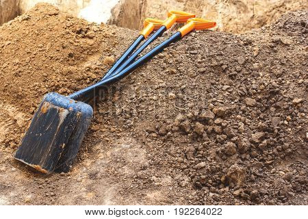 The tools of the shovel lie on the brown ground