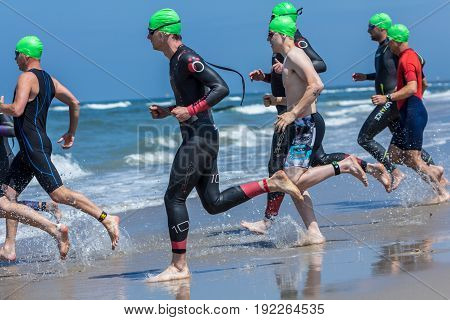 Kijkduin The Hague the Netherlands - 17 June 2017: Kijkduin cross triathlon athletes running into the sea for swimleg
