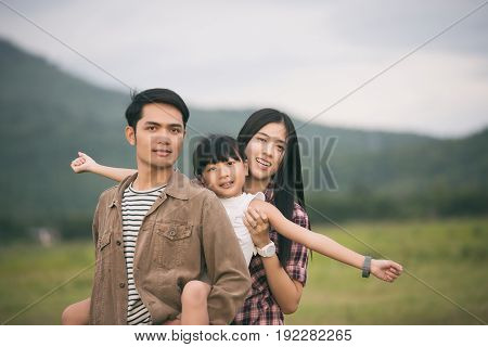 Happy family having fun and enjoying journey in the park at the sunset time
